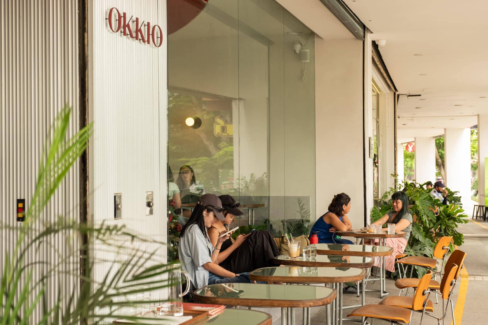 The outdoor area at Okkio Caffe is surrounded by greenery, offering a breezy, peaceful vibe perfect for early mornings or late afternoons